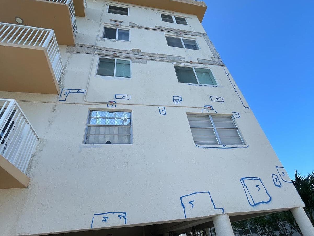Condo facade marked in blue with numbered boxes identifying each spalling repair