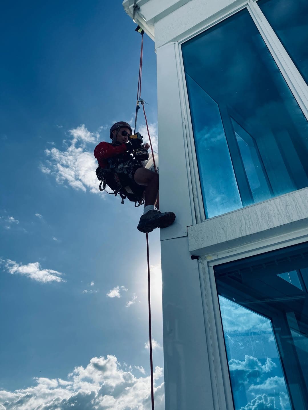 Basile technician on rope access alongside a high-rise glass facade